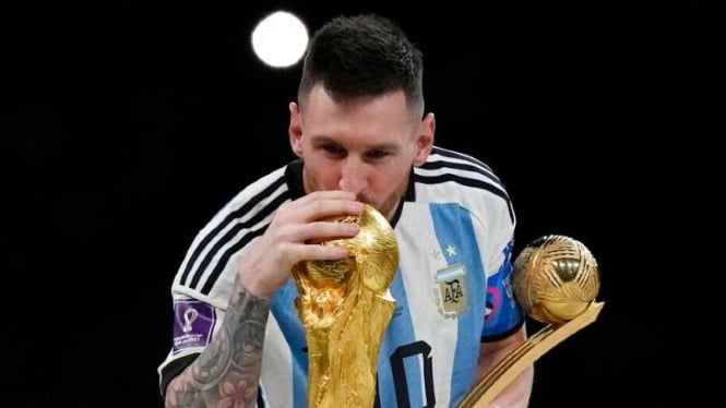 Kapten Timnas Argentina, Lionel Messi mencium trofi Piala Dunia 2022.